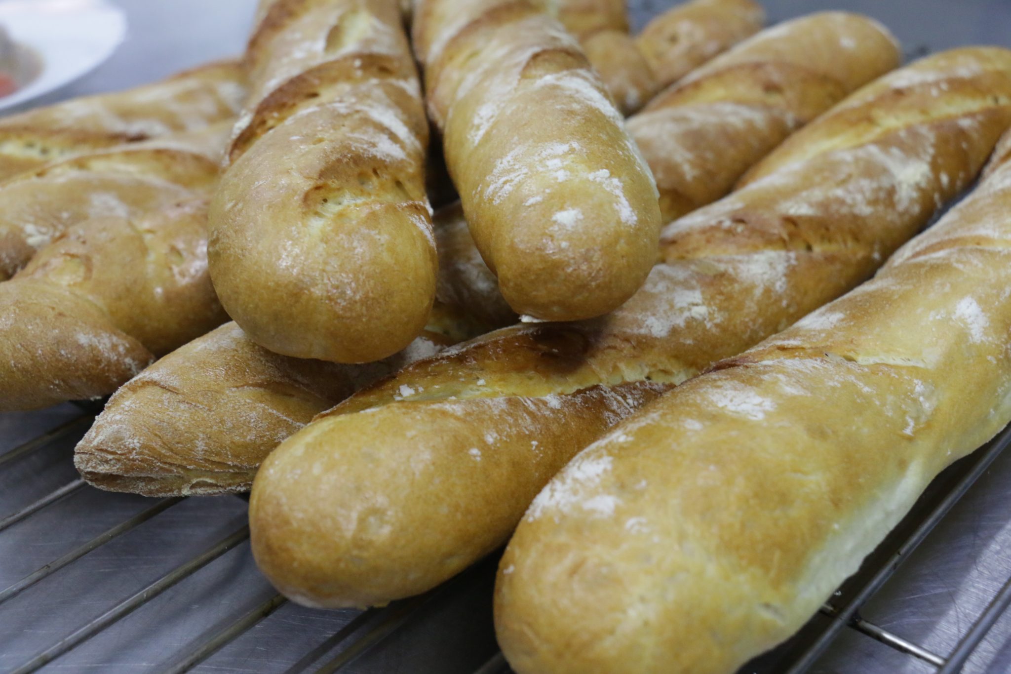 Baguettes dusted with flour cooling on a wire rack
